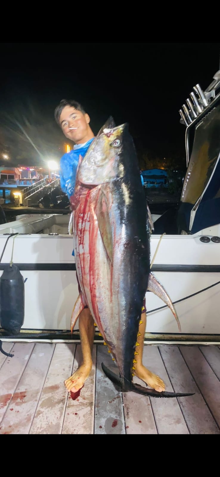Young angler with massive tuna at night